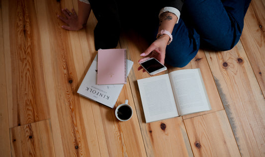 person holding cellphone up over books and coffee, blonder marketing